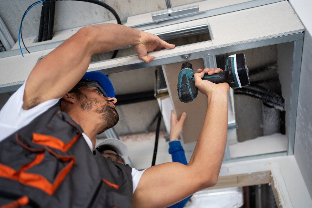 a person holding a drill to a metal beam